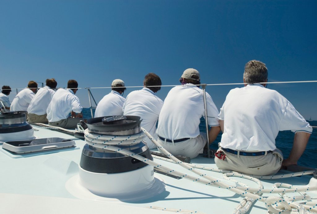 Deck Crew sat on a yacht with their backs to the camera | Green Yacht Crew uniform tips