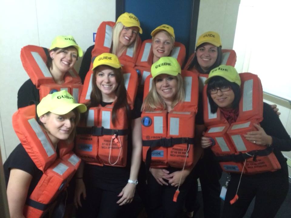 Heather pictured top left with crew mates wearing life jackets and neon caps with "Guide" written on them